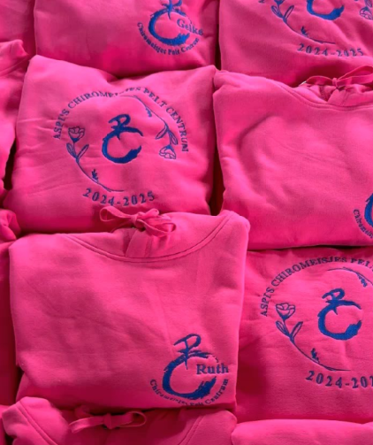 Groepstruien logo in midden met daarrond bloemetjes, groepsnaam & jaartal