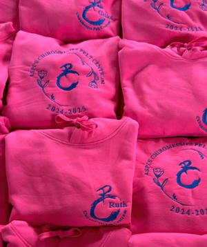 Groepstruien logo in midden met daarrond bloemetjes, groepsnaam & jaartal